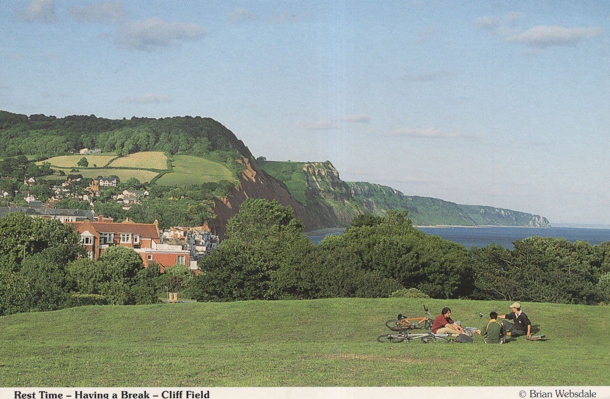 Sidmouth Picnic On Cliff Field Trashed Bicycles Devon Postcard